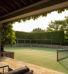 a person on a tennis court with a racket and ball in the foreground