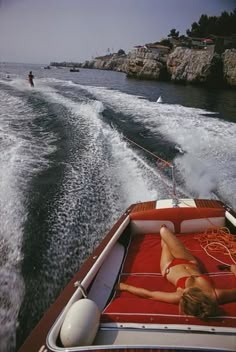 a woman laying on the back of a boat