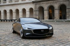 a black car parked in front of a large building with arches on it's sides