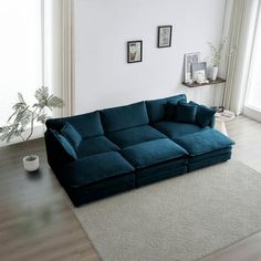 a blue couch sitting on top of a hard wood floor next to a white rug