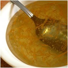 a white bowl filled with soup and a silver spoon in it's left side