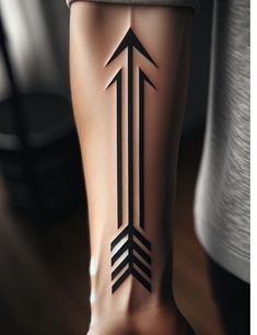 an arrow tattoo on the back of a person's leg