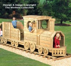 a wooden toy train with three children riding on it