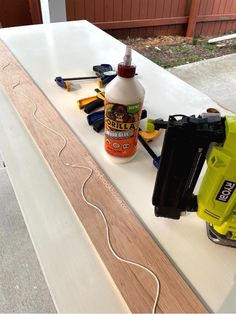 the glue is being used to paint the top of an unfinished piece of white wood