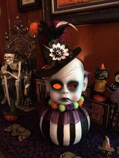 an odd looking doll is sitting on a table with other dolls and decorations around it