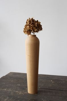 a wooden vase with some flowers in it