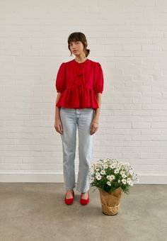 a woman standing next to a potted plant