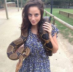 a woman holding a large snake in her arms