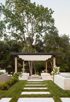 a gazebo in the middle of a garden with steps leading to an outdoor pool