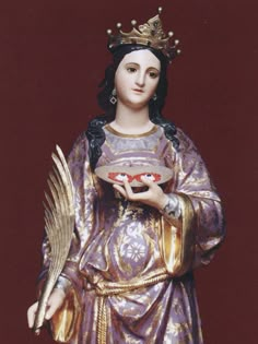 a statue of a woman holding a plate with an angel on it's arm