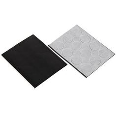 two pieces of black and white paper sitting next to each other on a white surface