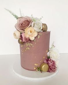 a pink and gold cake with flowers on top