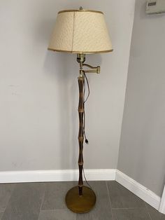 a lamp that is on top of a wooden stand with a light shade over it