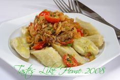 a white plate topped with pasta and veggies next to a knife and fork