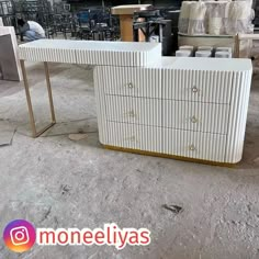 a white and gold dresser sitting on top of a floor