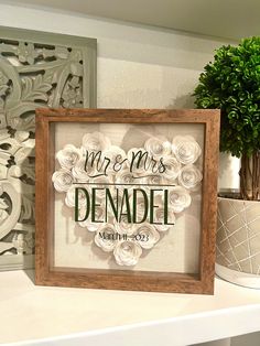 a wooden framed sign that says mr and mrs denadel with flowers on it