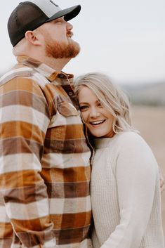 a man standing next to a woman on top of a field