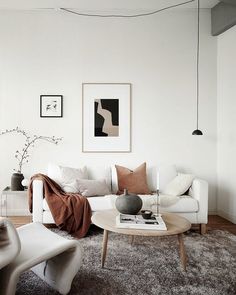 a living room filled with furniture and decor on top of a hard wood floored floor