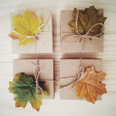 four wrapped gift boxes with autumn leaves on them