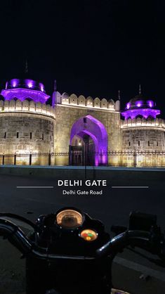 a motorcycle parked in front of a building with purple lights on it's side