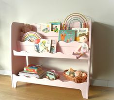 a pink shelf with books and toys on it