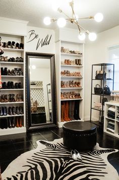 a zebra print rug in front of a mirror and shoe rack with shoes on it