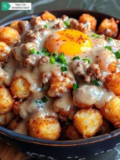 a bowl filled with tater tots covered in gravy and an egg