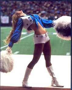 a cheerleader performing on the sidelines at a football game