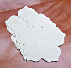 four white paper cut outs sitting on top of a bed