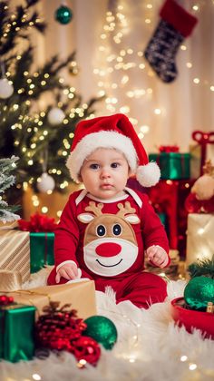 a baby wearing a santa claus outfit sitting in front of christmas decorations and presents on the floor