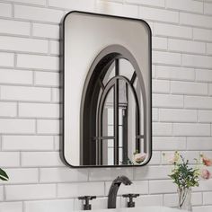 a bathroom sink sitting under a mirror next to a white brick wall with flowers in it