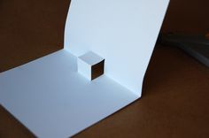 an open white box sitting on top of a table next to a pair of scissors