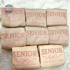 six small bags with pink ribbon on them sitting on a white carpet next to each other