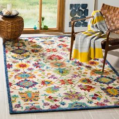 a living room area with a chair and rug on the floor in front of a window