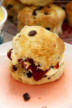 a scone with jam and raisins on it