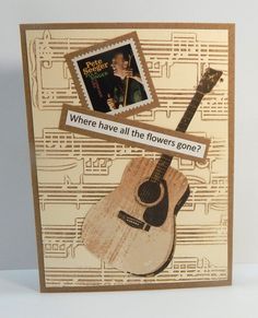 a card with an image of a guitar and a postage stamp on it that says, where have all the flowers gone?