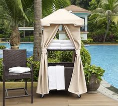 an outdoor gazebo next to a pool with towels on it and a chair in the foreground