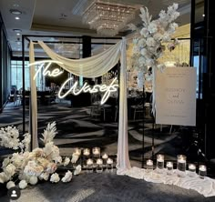 a wedding setup with candles and flowers in front of the sign that says the reception