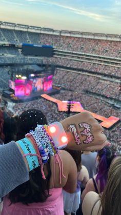 a person with bracelets on their wrist at a concert in front of an audience