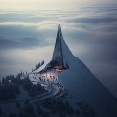 a very tall building sitting on top of a snow covered mountain in the middle of winter