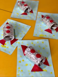 four pieces of tin foil on top of some red and white papers with holes in them