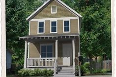 a small house sitting on the corner of a street with trees in front of it