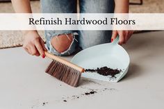 a woman is cleaning the floor with a broom and dustpan while sitting on the floor