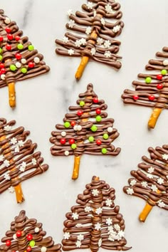 chocolate christmas tree cookies are arranged on a white countertop with candy and candies