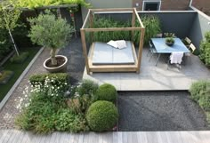 an aerial view of a small garden with table, chairs and bench in the middle