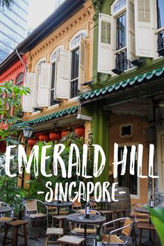 there are many tables and chairs in front of the building that says emerald hill singapore