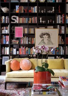 a living room filled with furniture and bookshelves covered in lots of bookcases