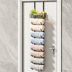 a rack with towels hanging from it's side in front of a white door