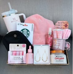 the contents of a woman's gift box are displayed on a gray couch next to a coffee cup