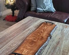 a coffee table made out of wood and metal with a wooden board on it's edge